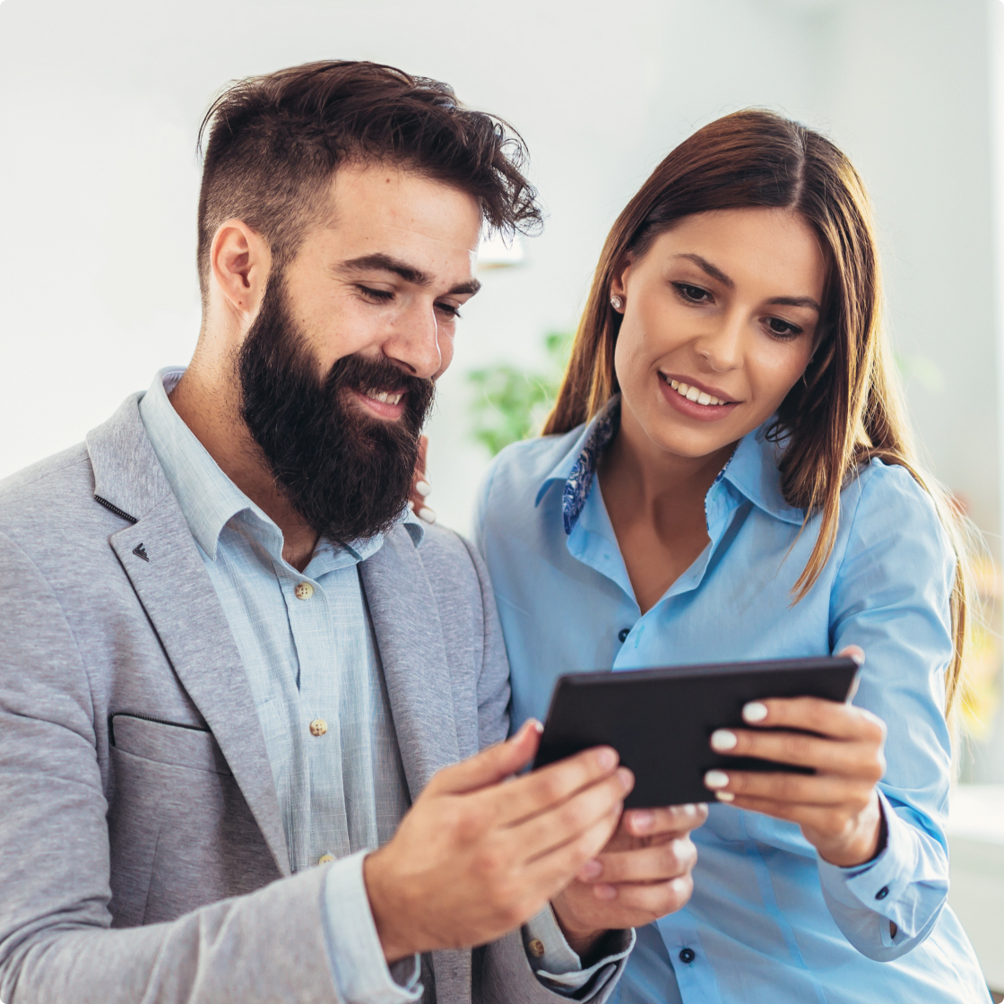 Man and woman looking at tab in office